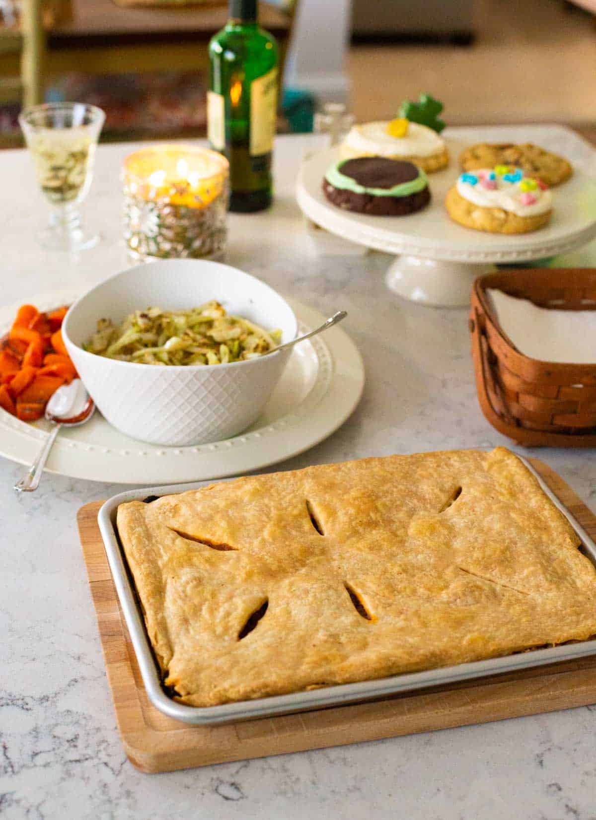 The baked pie is on the counter next to the rest of the dinner.