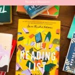 A copy of The Reading List sits on a table surrounded by other books.