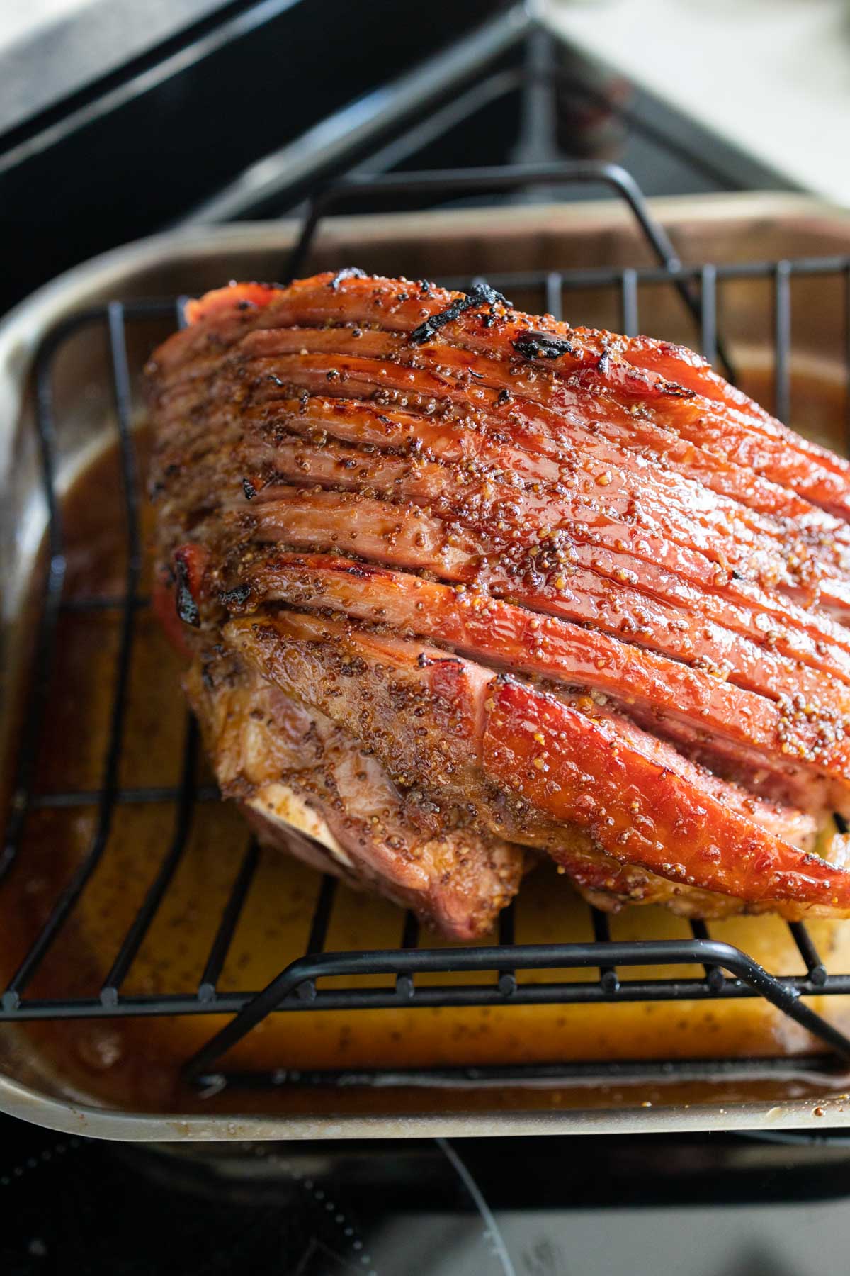 The spiral ham has been brushed with thickened glaze and then broiled for slightly charred crispy edges.