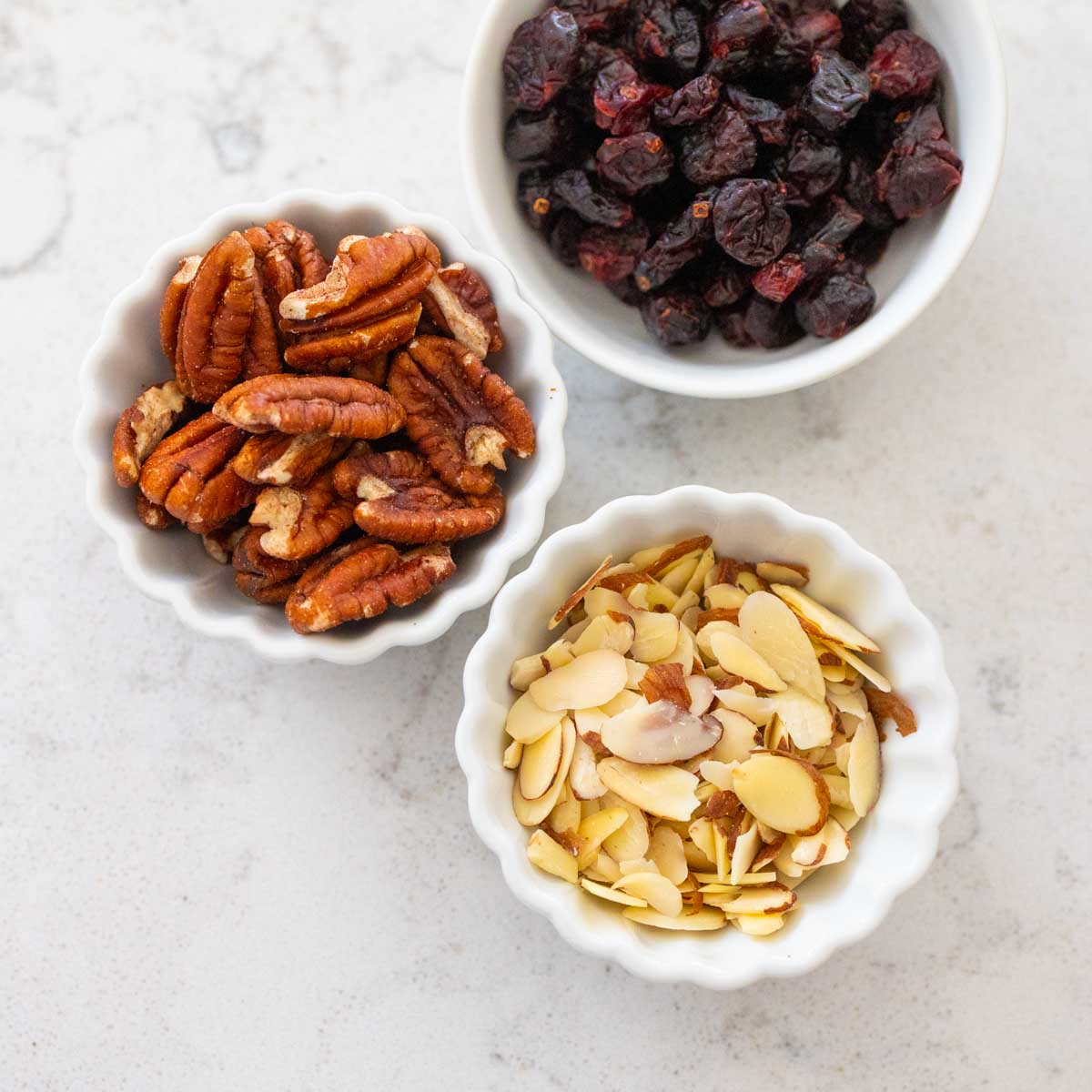 Tiny prep bowls are filled with dried fruit and nuts.
