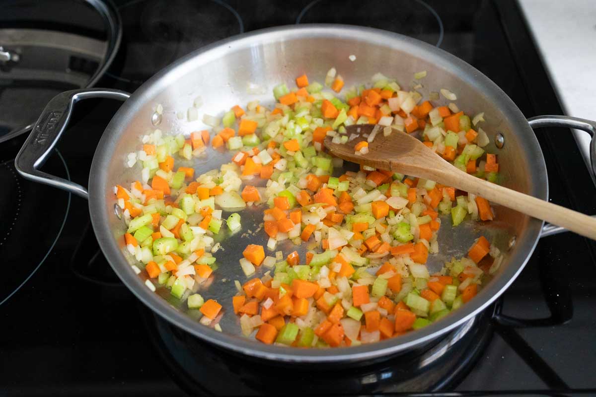 The carrots, celery, and onions are cooking in a large skillet.