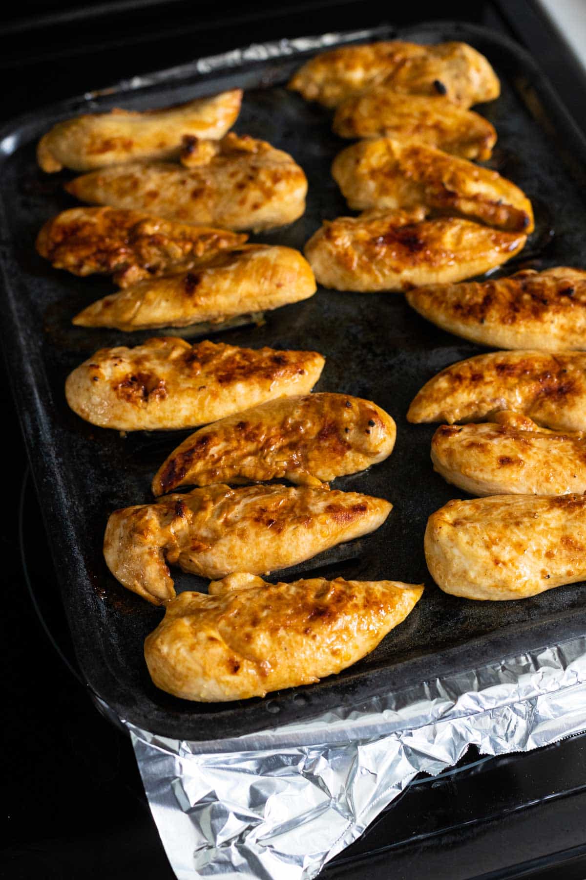 The chicken tenderloins are golden brown and slightly crispy after being under the broiler.