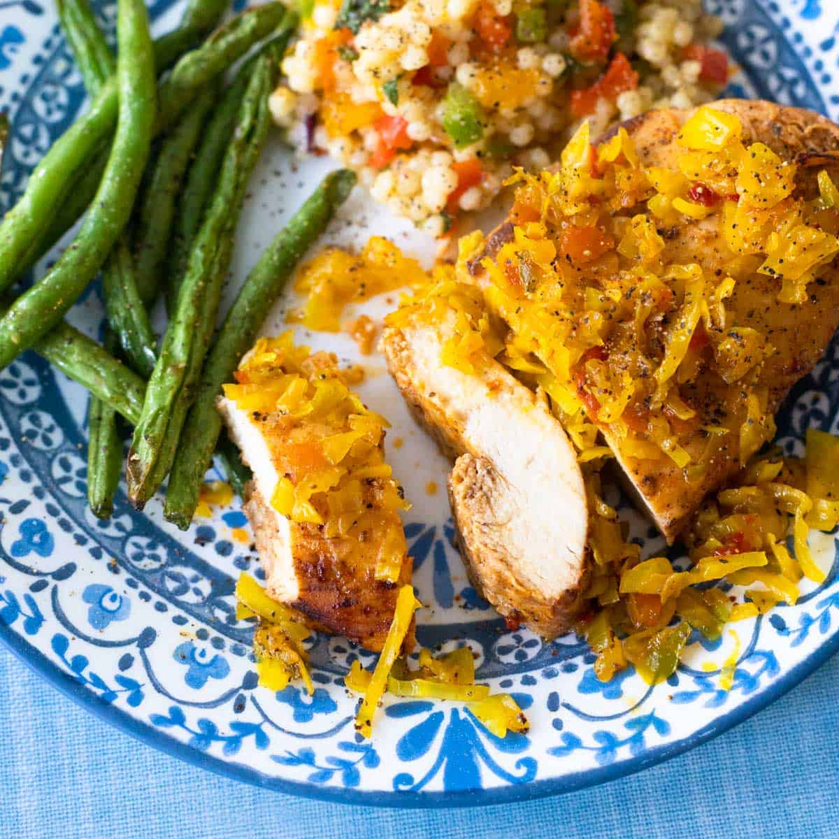 The relish has been added to the top of a baked chicken breast