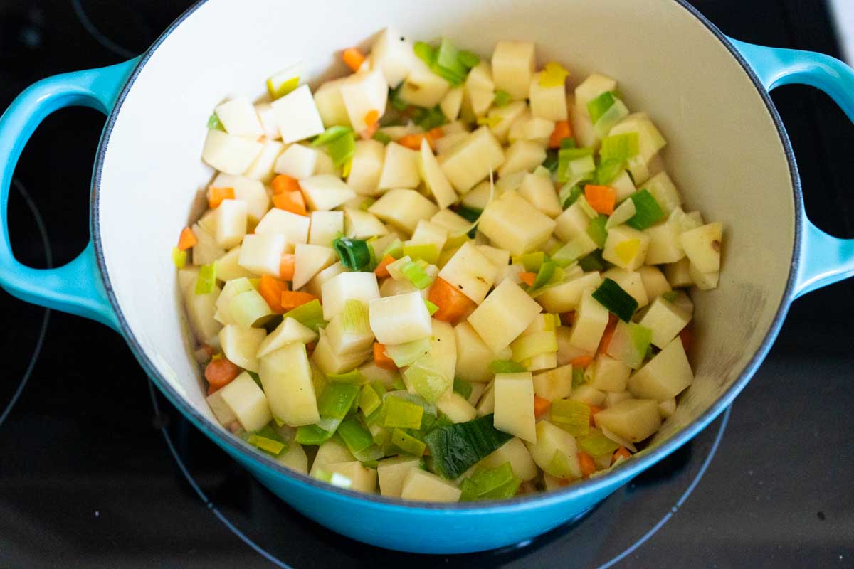 The chopped potato and other vegetables are now cooking in the pot.
