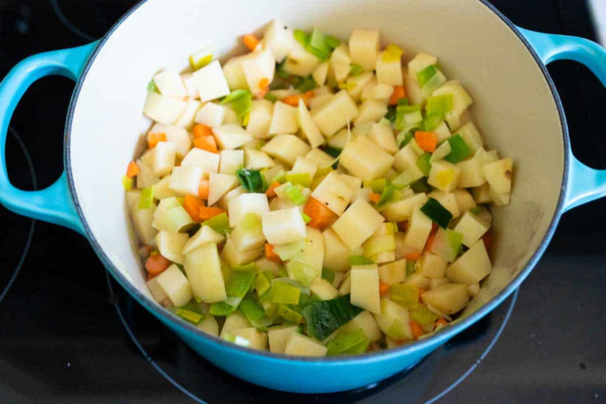 The chopped potato and other vegetables are now cooking in the pot.