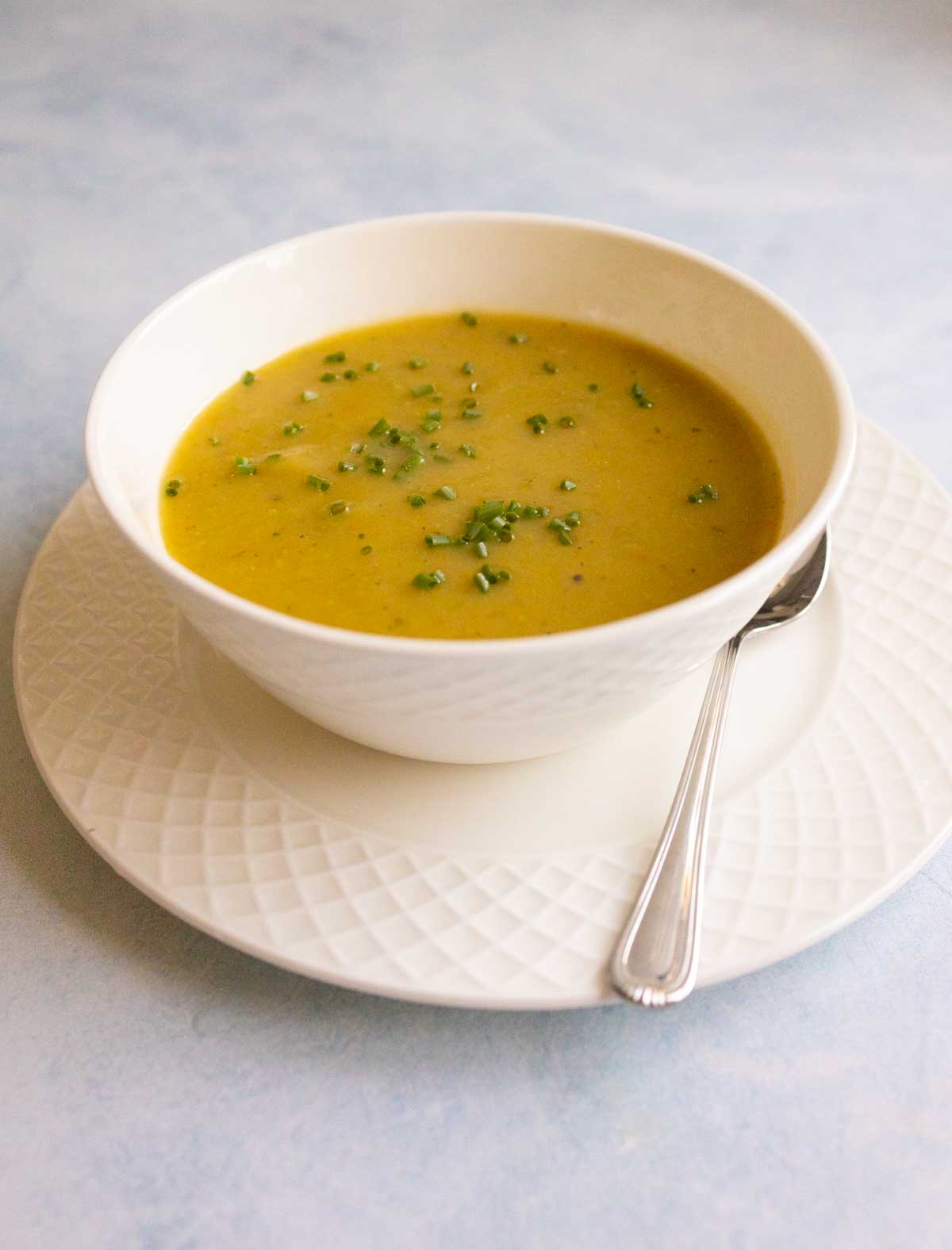 The finished soup is in a white bowl with a spoon.