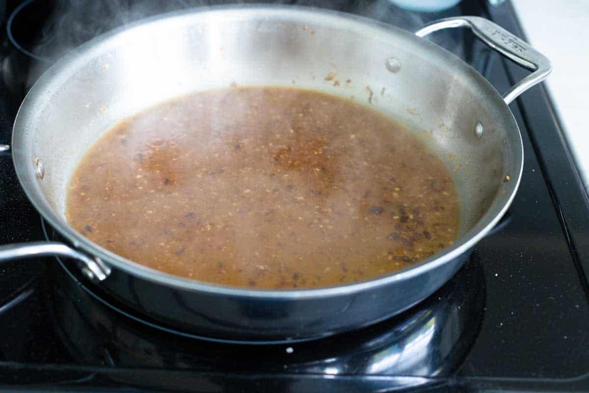 The white wine is in the skillet and simmering with steam.