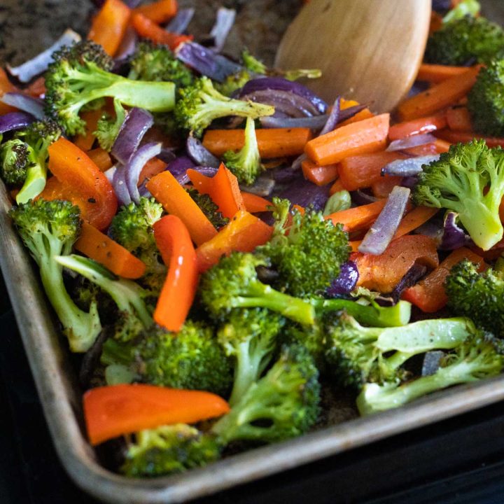 A baking sheet is filled with roasted broccoli and carrots.