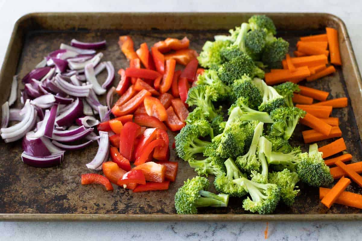 The veggies have been chopped and placed on a large baking sheet.