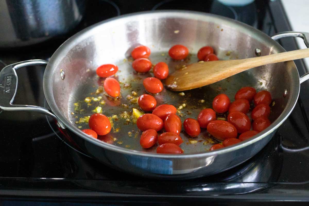 The cherry tomatoes have been added to the skillet.