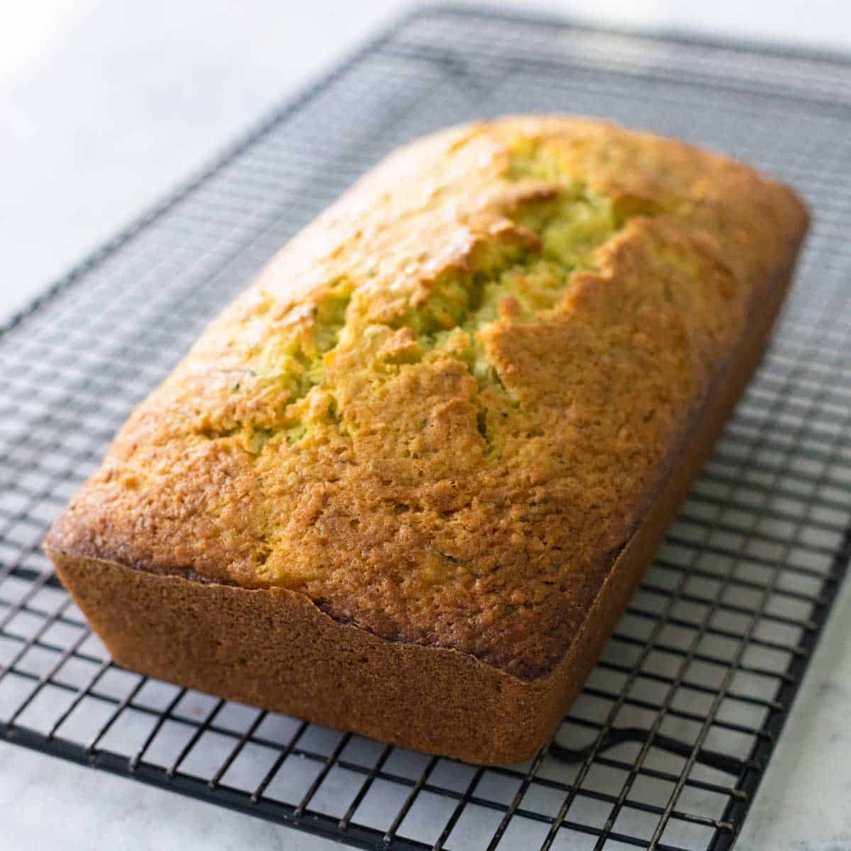 The quick bread rests on a cooling rack.