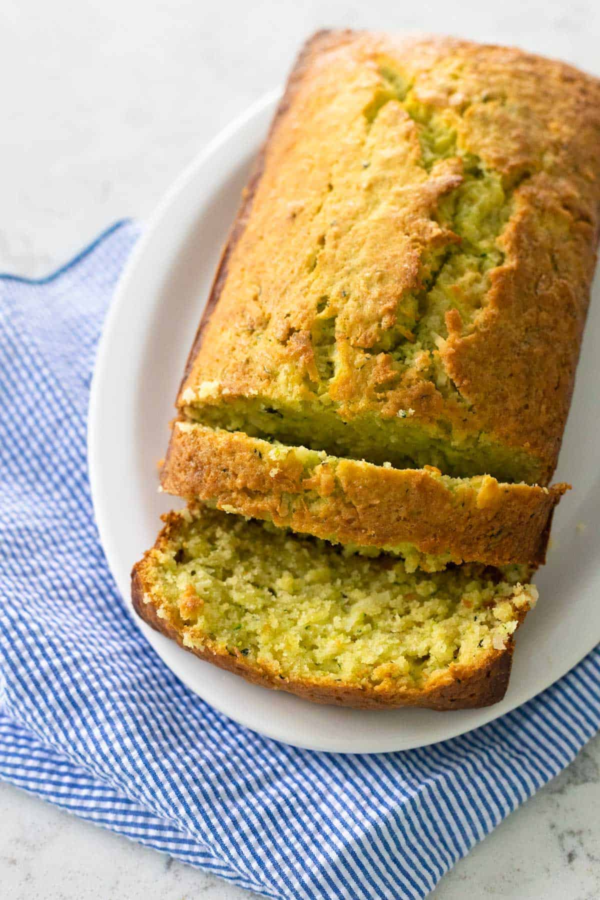 The finished loaf is on a serving platter with a few pieces sliced to show the texture.