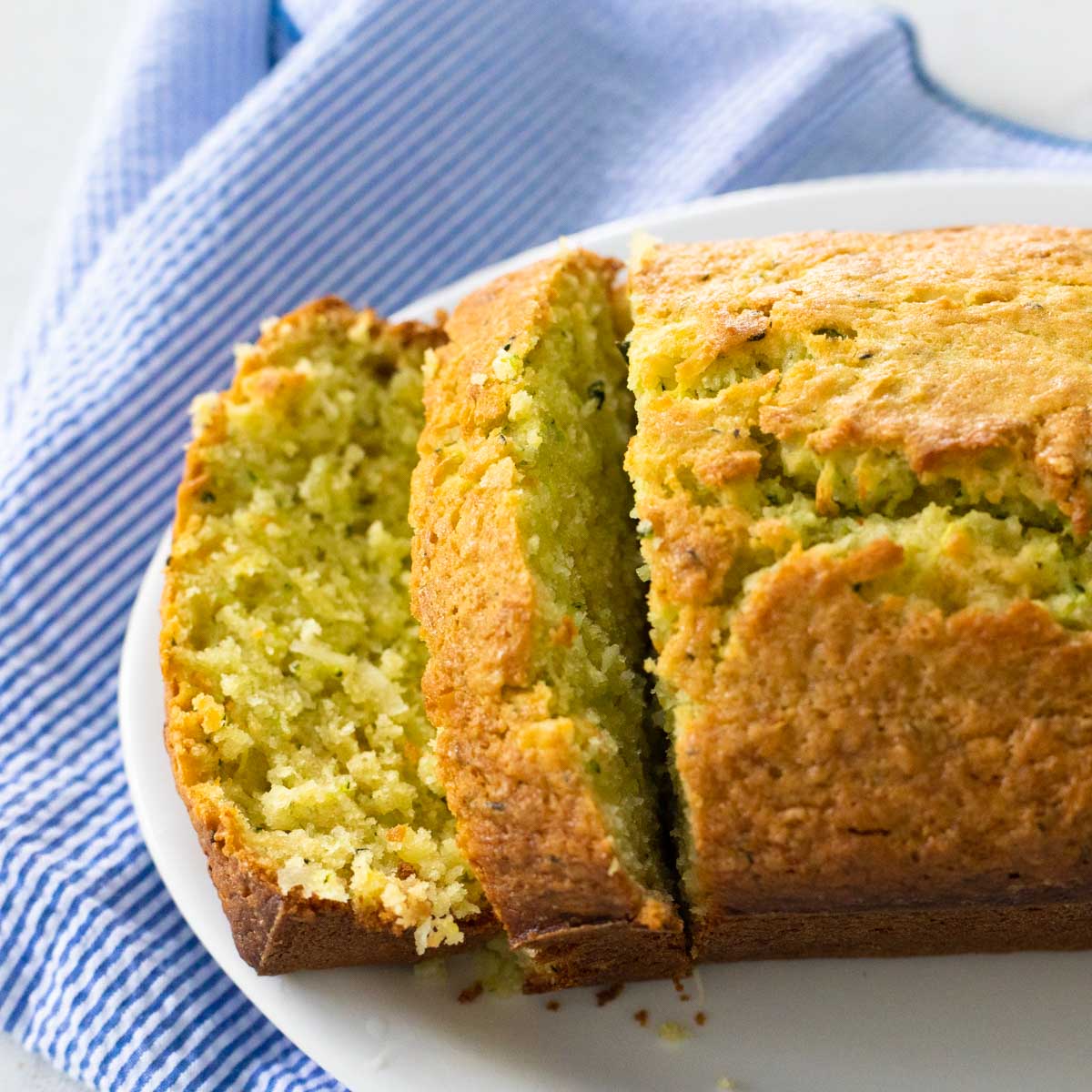 A loaf of pineapple zucchini bread has been sliced to show the texture of the bread.