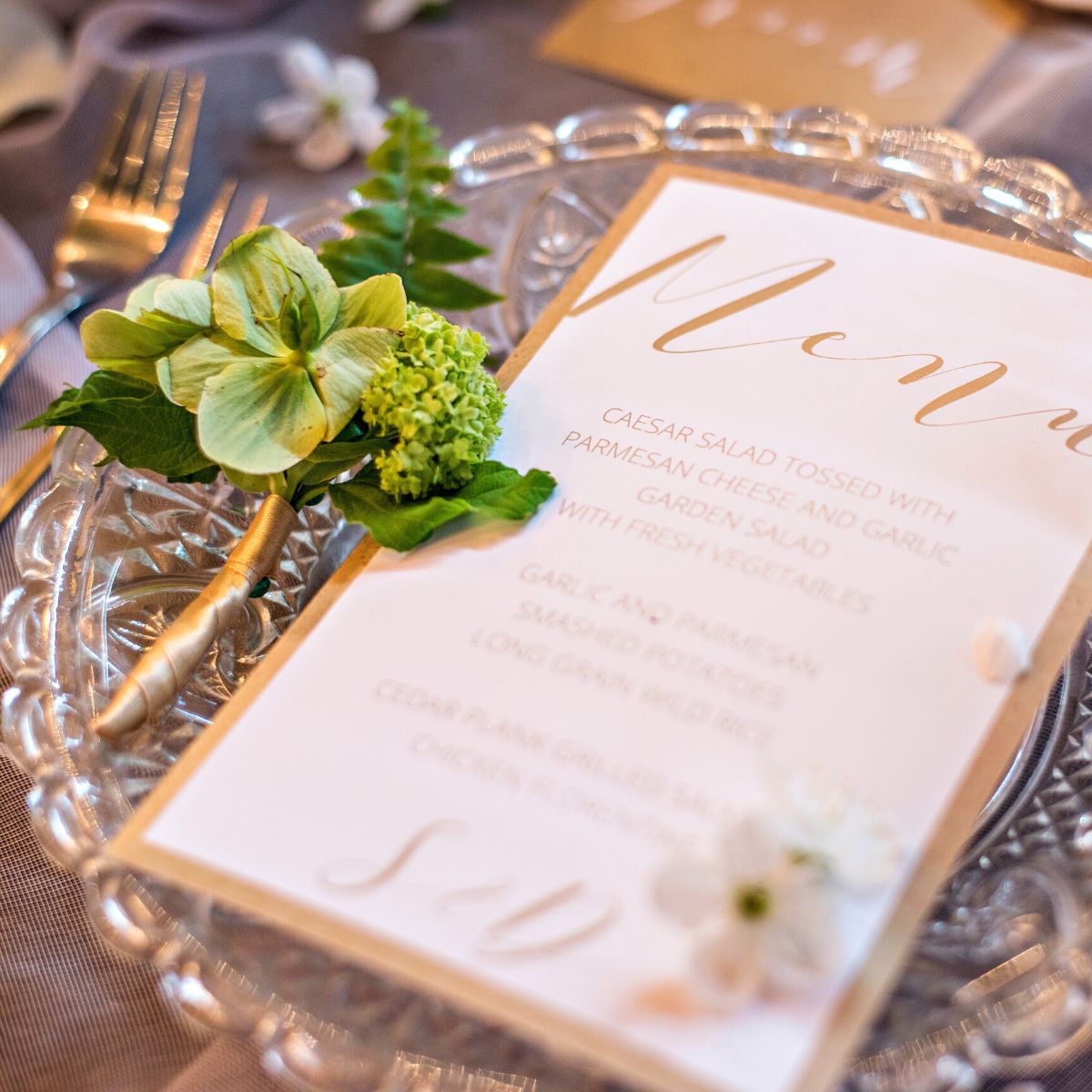 A printed menu on a glass plate with a flower corsage next to it.