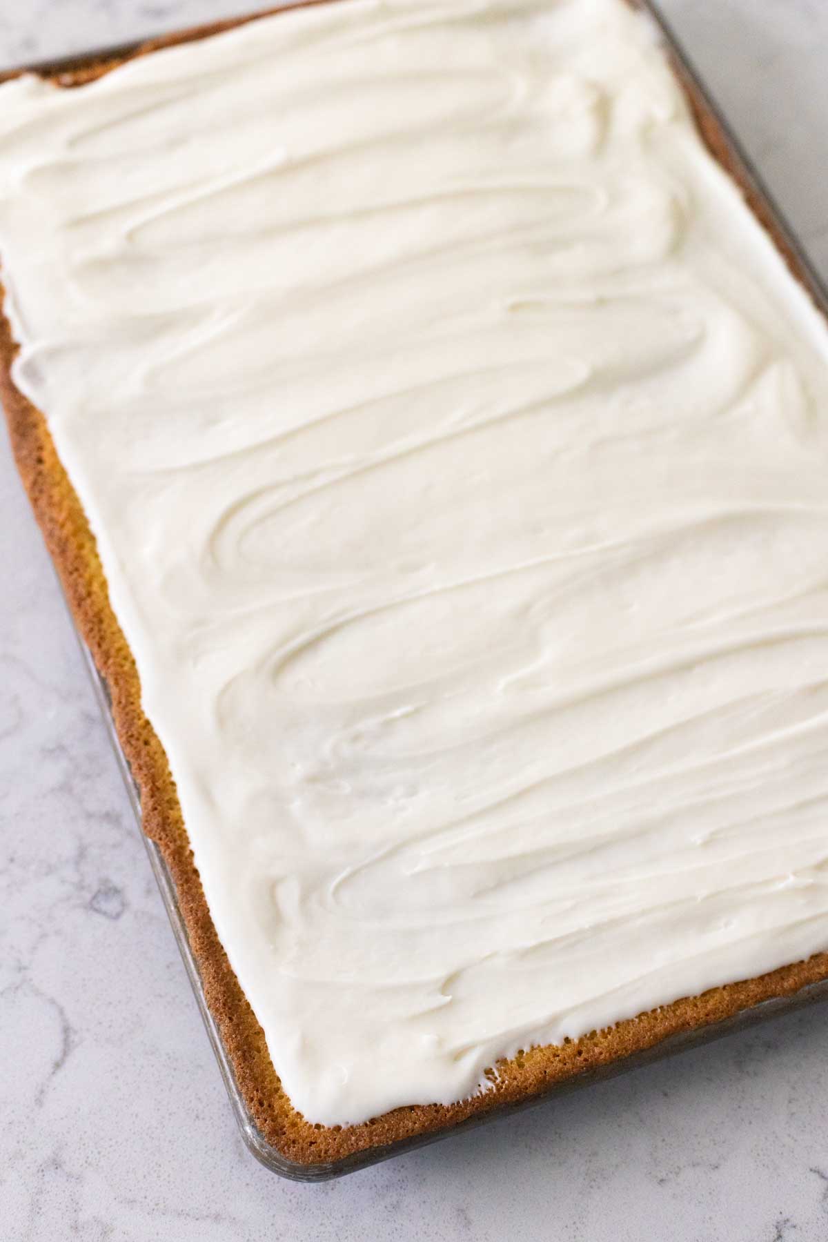 The cake has the almond icing spread evenly over the top. Pretty swirl marks cover the top of the cake.