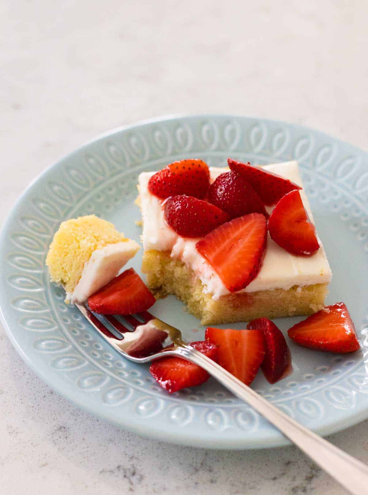 The cake has been served with fresh strawberries over the top.