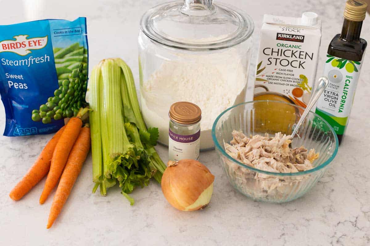 The shredded chicken and vegetables are on the kitchen counter.