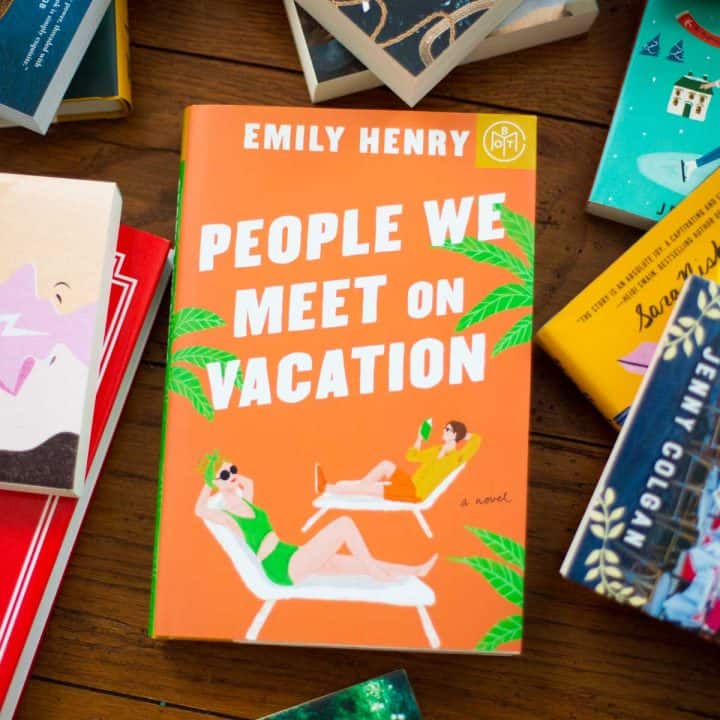 A copy of People We Meet on Vacation by Emily Henry sits on a table.
