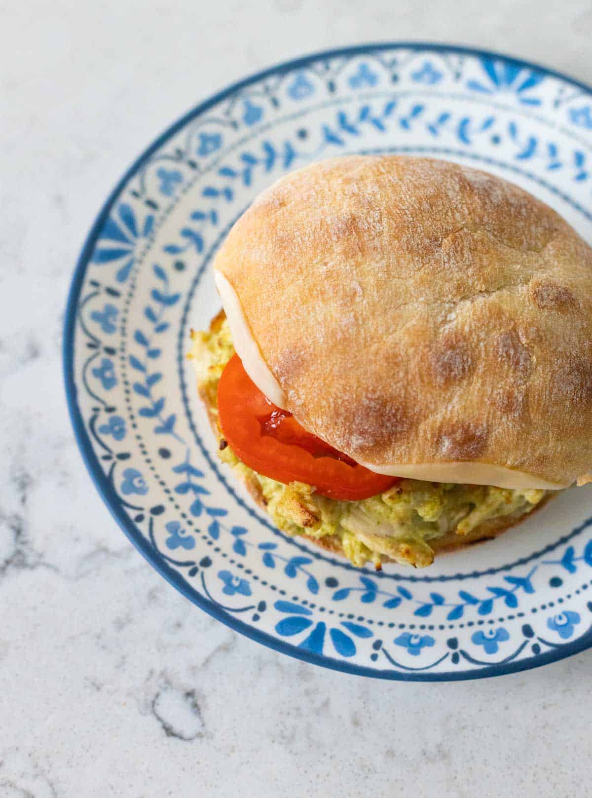 The finished sandwich is assembled and served on a blue and white plate.