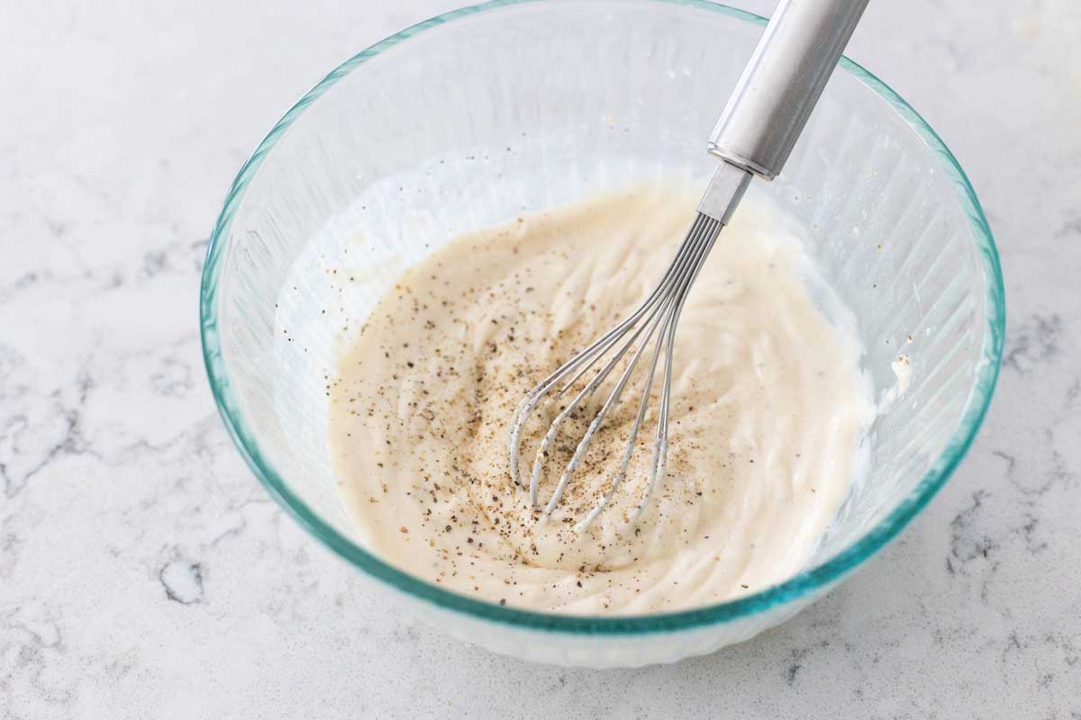 The dressing has been whisked together in a medium sized mixing bowl.