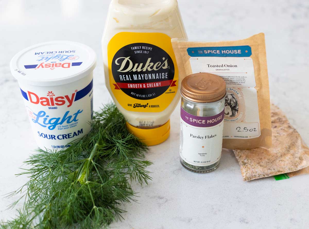 The ingredients to make a homemade dill dip are on the kitchen counter.