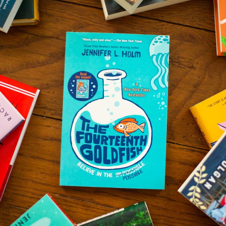 A copy of The Fourteenth Goldfish by Jennifer L. Holm sits on a table.