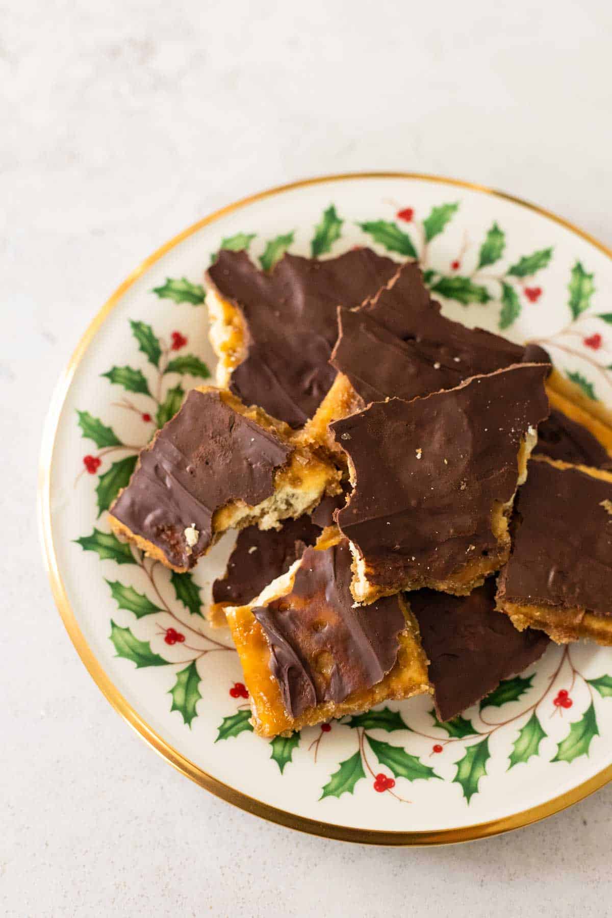 A Christmas china plate has a pile of saltine cracker candy.