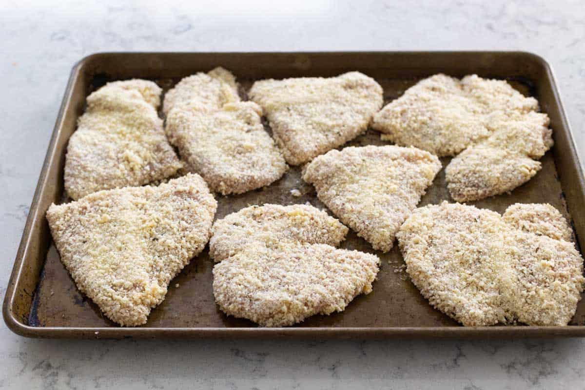 The finished chicken is ready to bake on a large baking sheet.