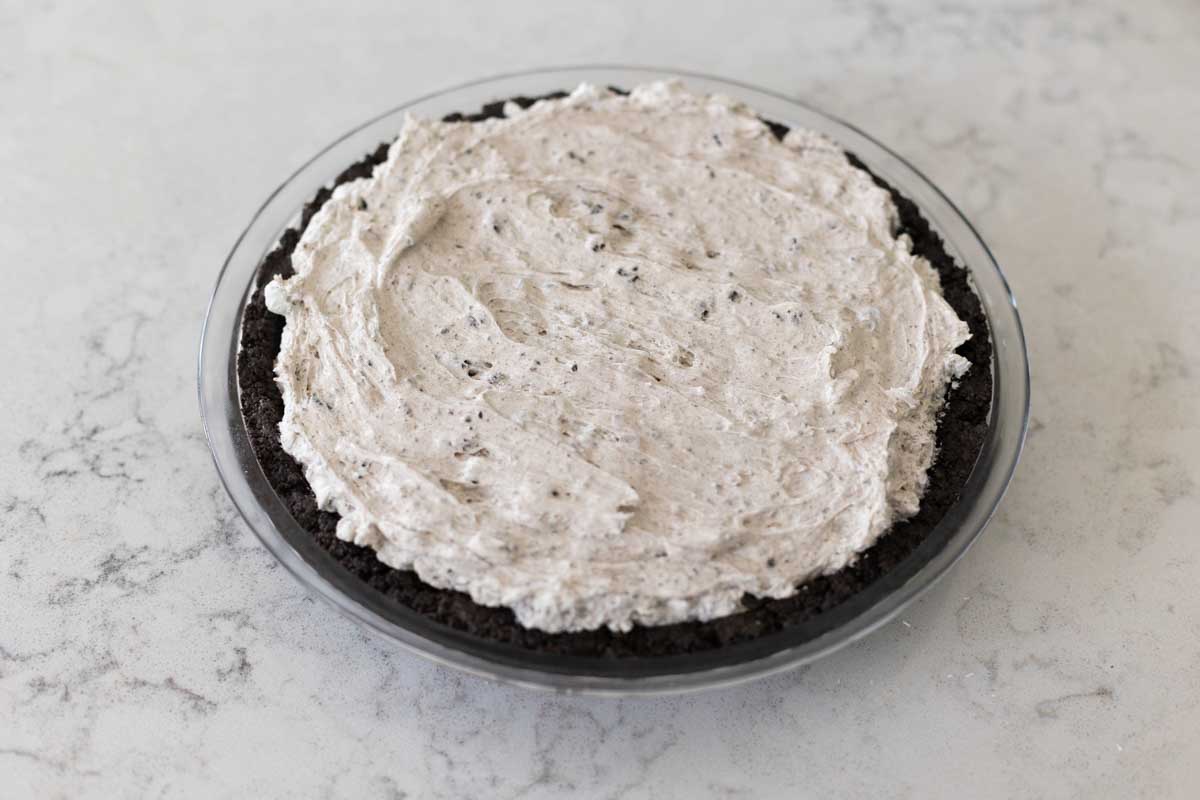 The Oreo cream layer is added to the Oreo cookie crust first.