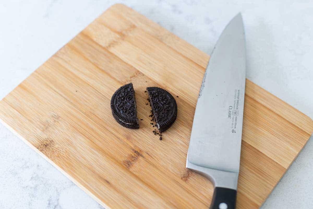 The Oreo cookie has been sliced into half with a chef knife.