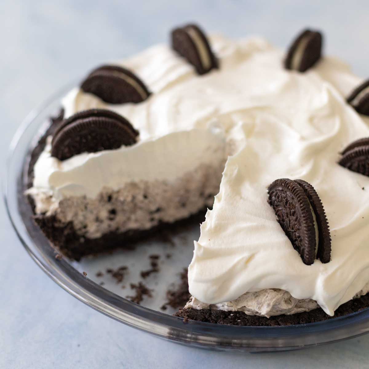 The oreo cream pie has one slice missing so you can see the cookie crust, oreo cookie cream center, and whipped topping.