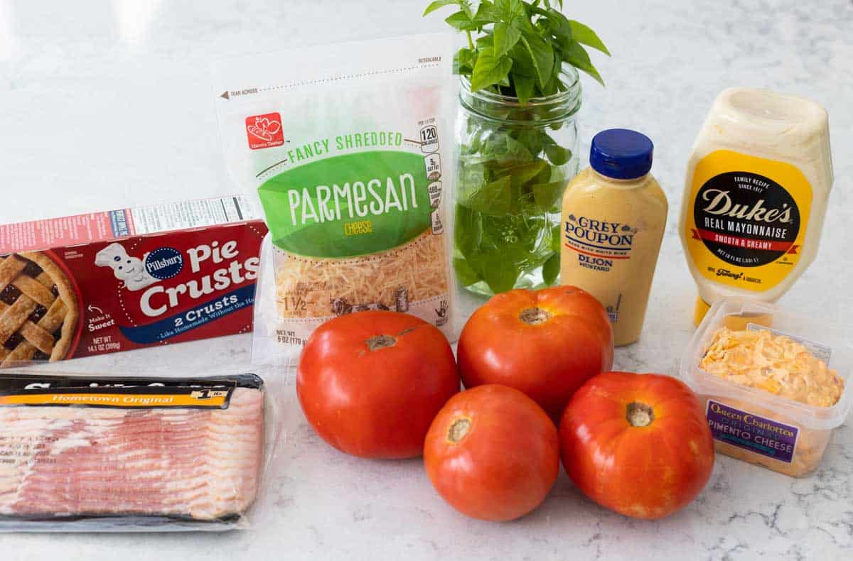 The fresh tomatoes are on the counter next to the rest of the easy pie ingredients.