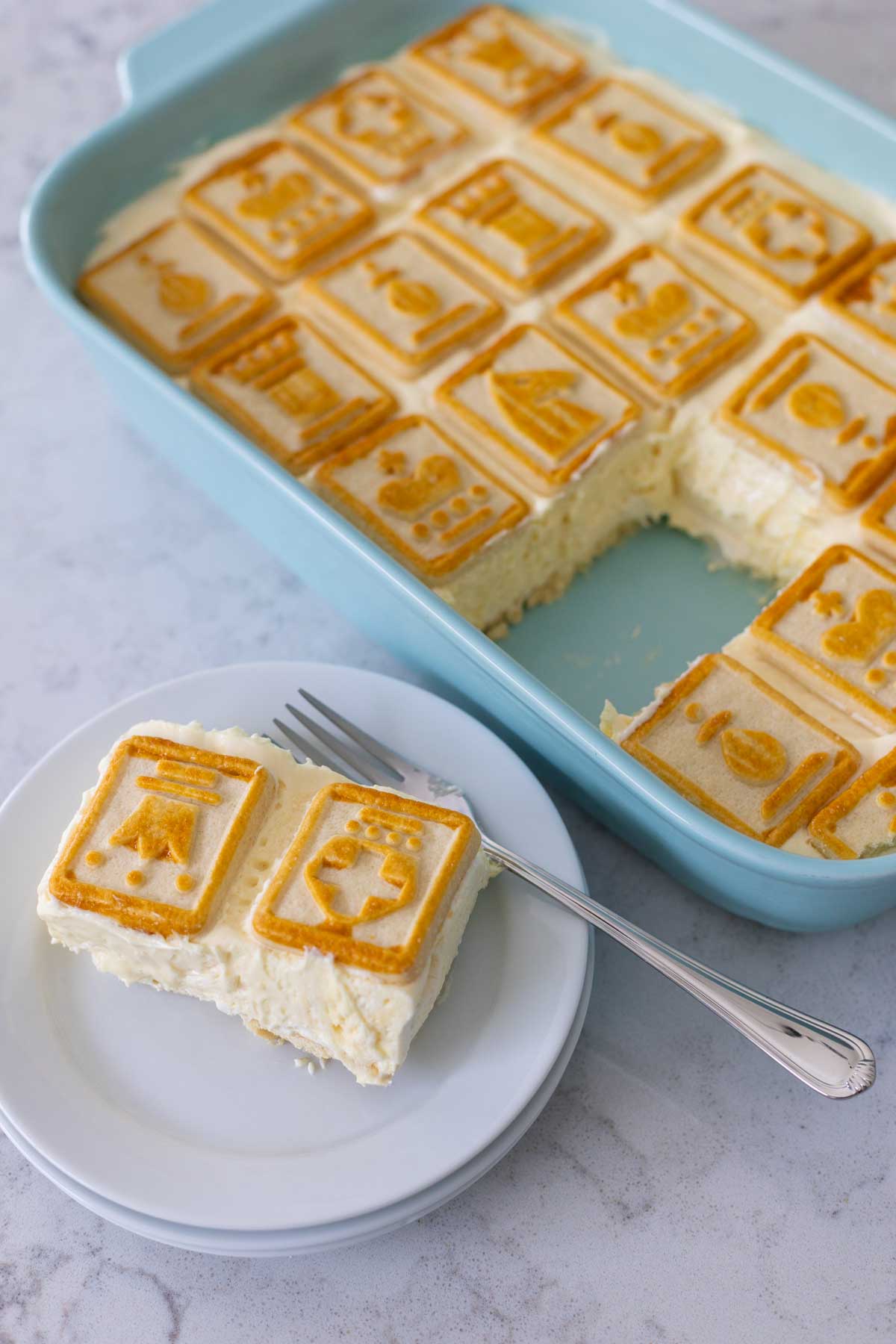 The slice of banana pudding without bananas is on a stack of plates. You can see the spot in the dish where it was cut, it came out cleanly and was easy to slice.