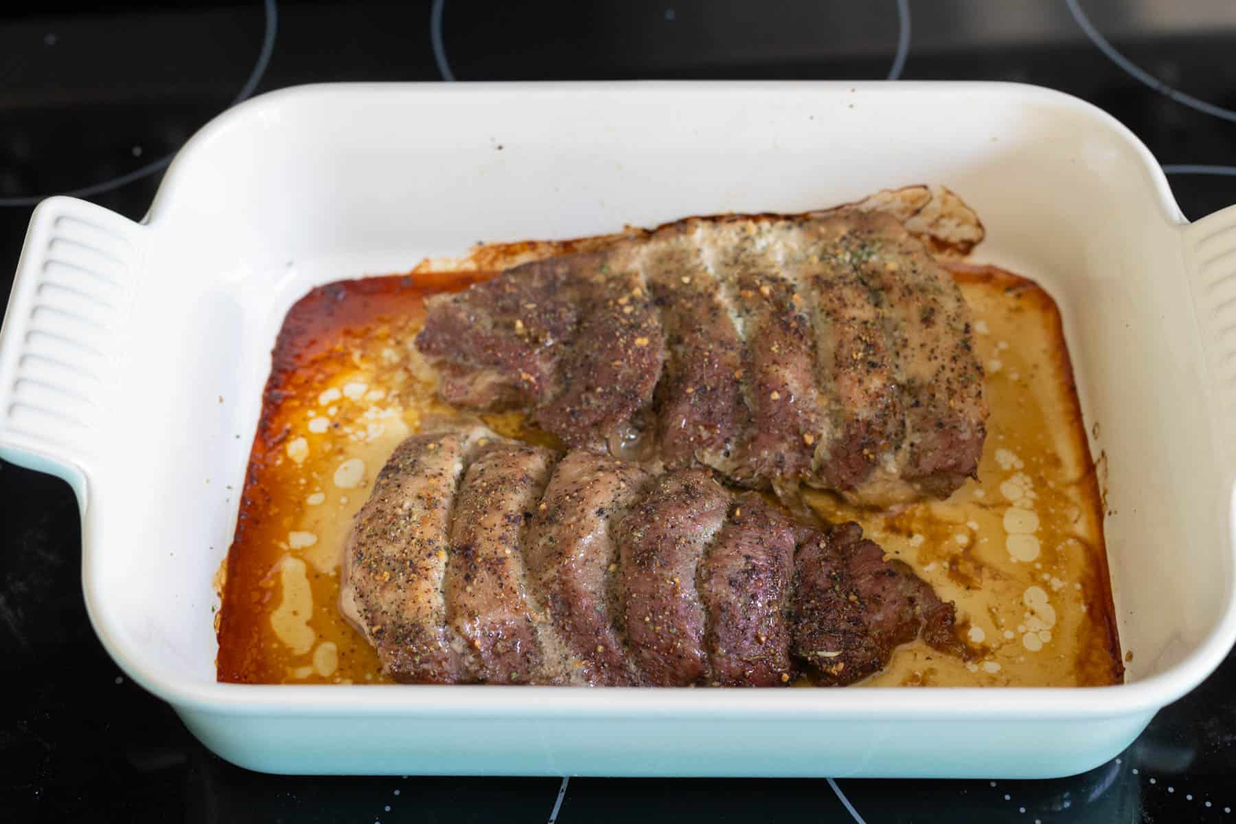 The boneless pork ribs have just come out of the oven, they are golden brown and the ribs have slightly separated.