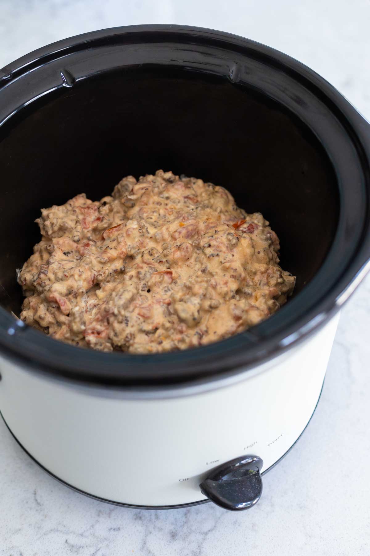 The slowcooker is filled with the sausage dip.