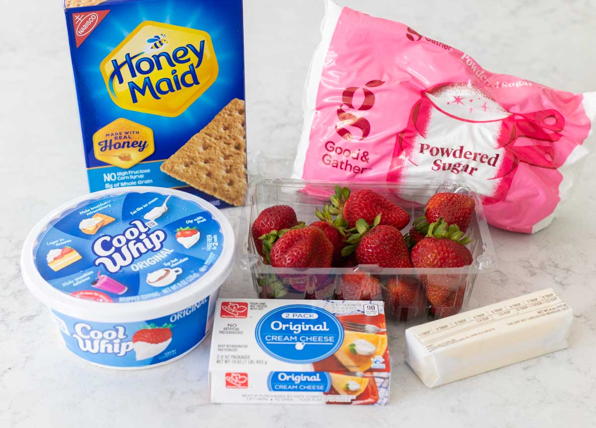 The ingredients to make a strawberry cream pie are on the counter.