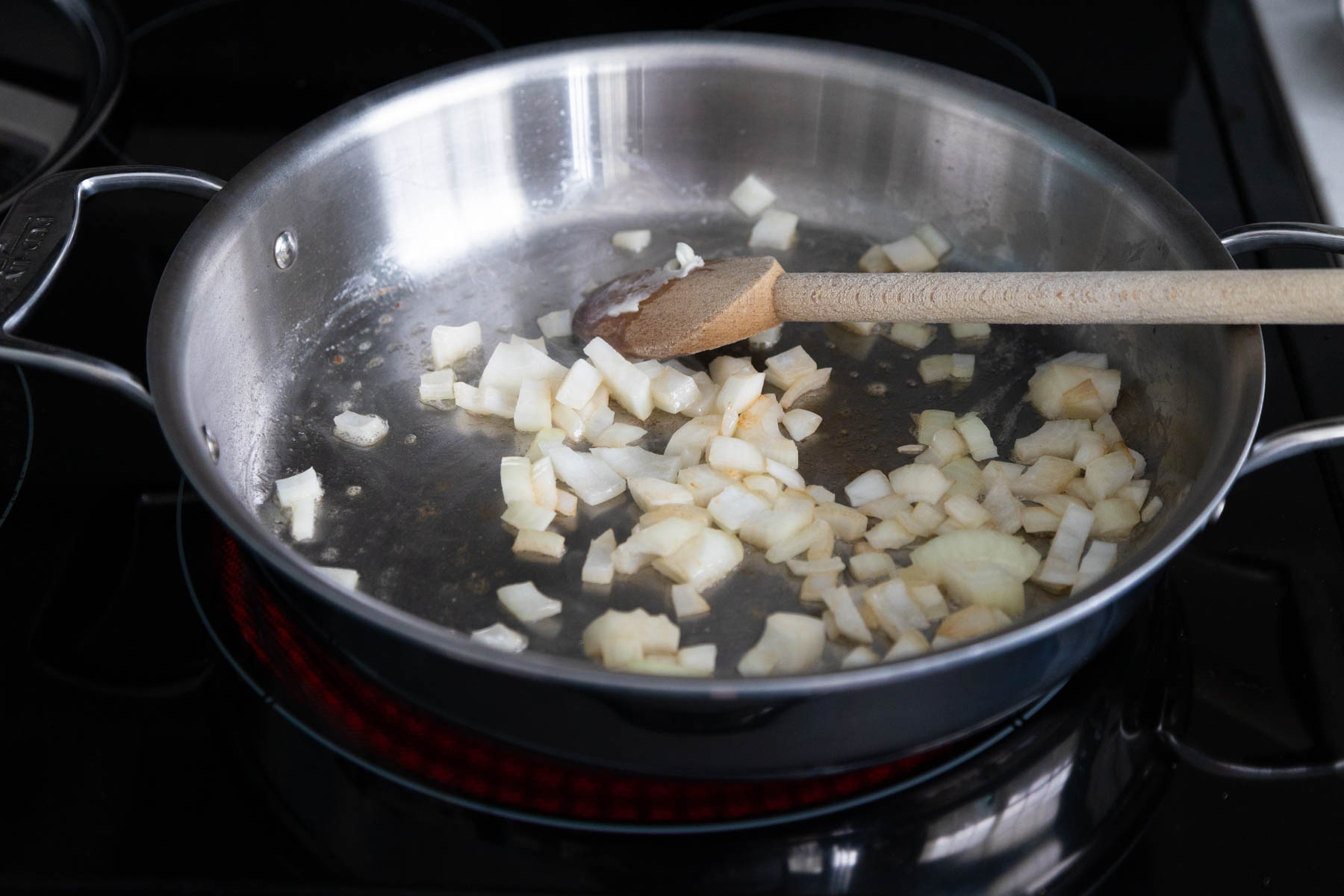 The chopped onion is in a large skillet with melted butter.