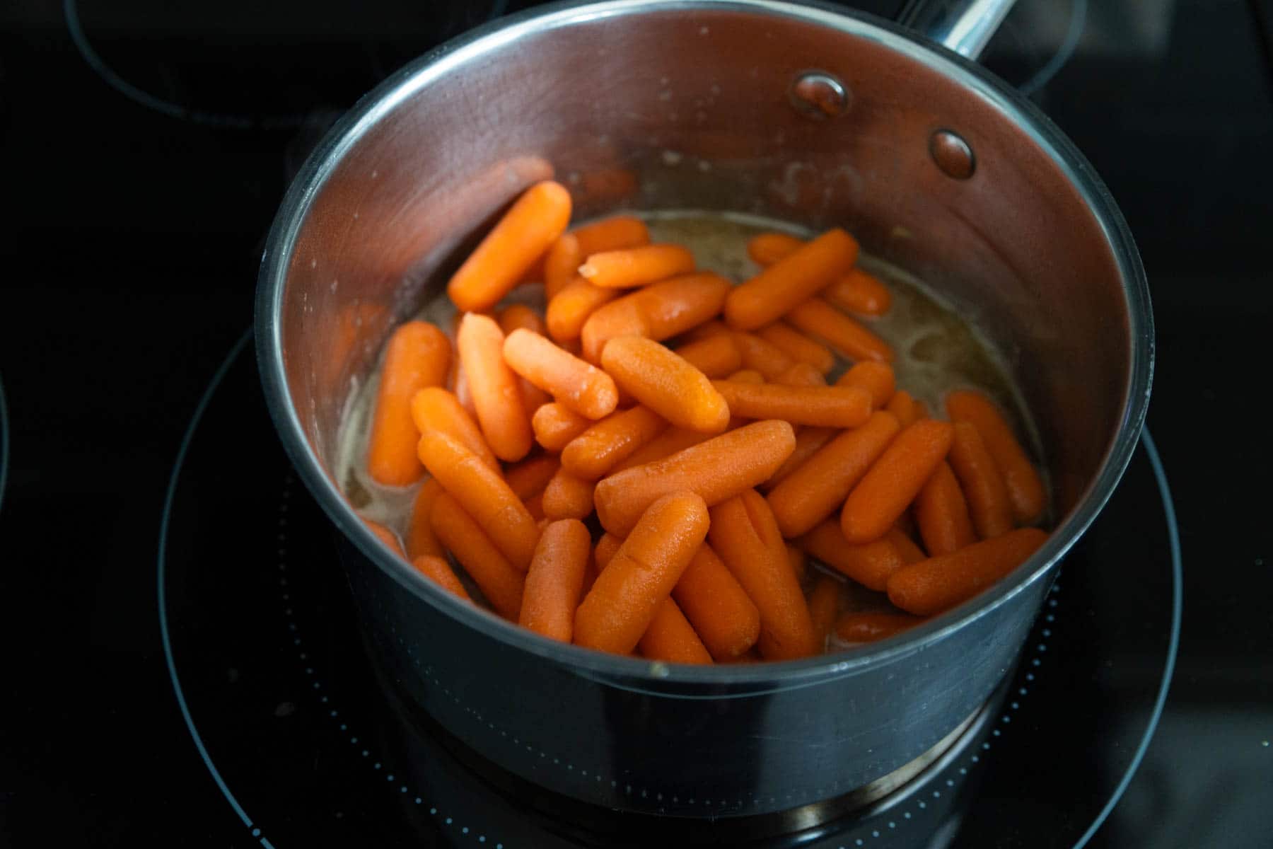The baby carrots have been stirred in and are about to cook.
