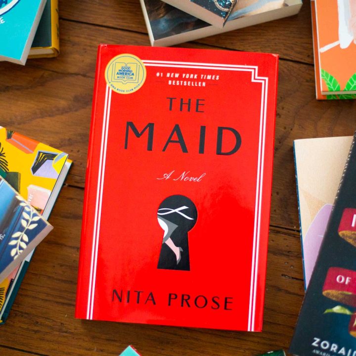 A copy of the book The Maid by Nita Prose sits on a table.