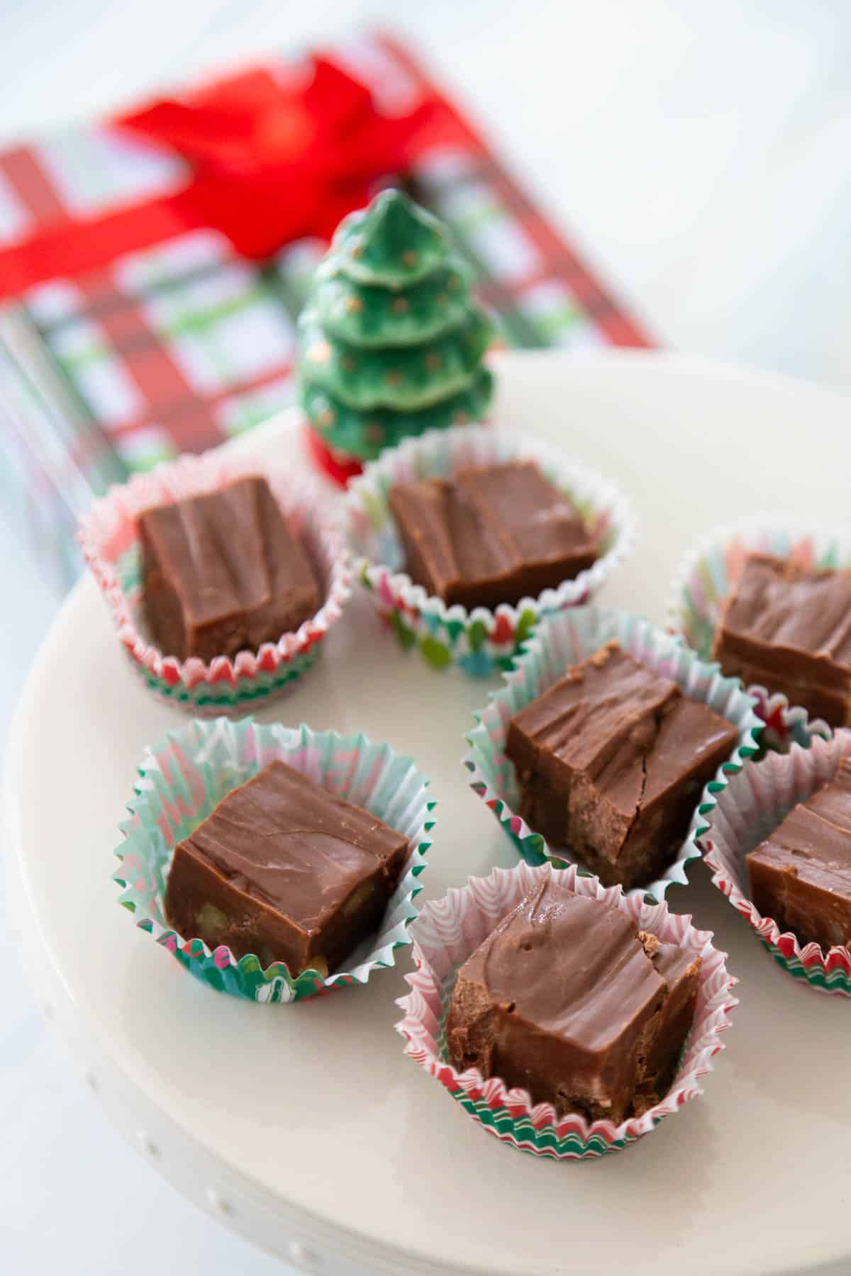 The squares of fudge are about to be packaged into a Christmas gift tin.