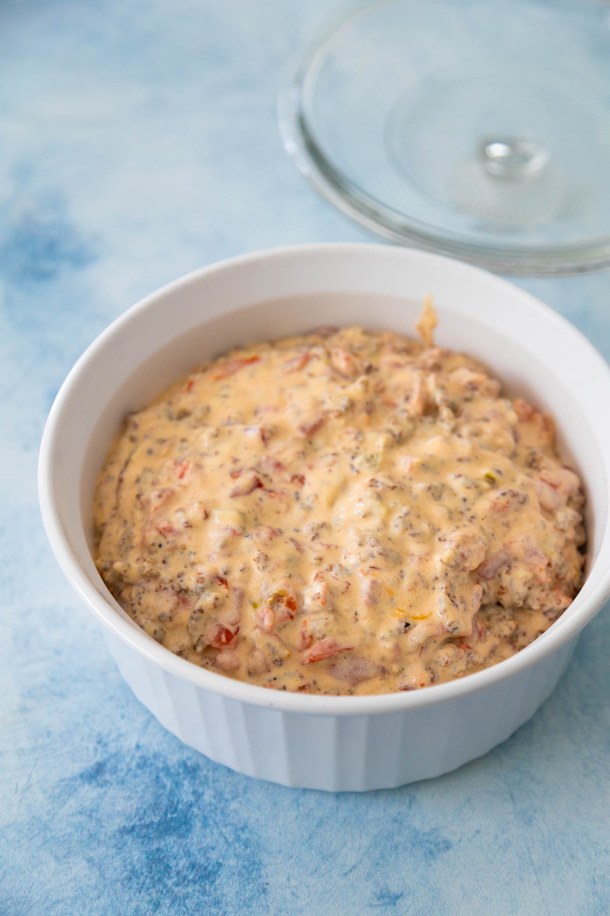 The prepared sausage dip is in a glass casserole dish ready to be refridgerated.