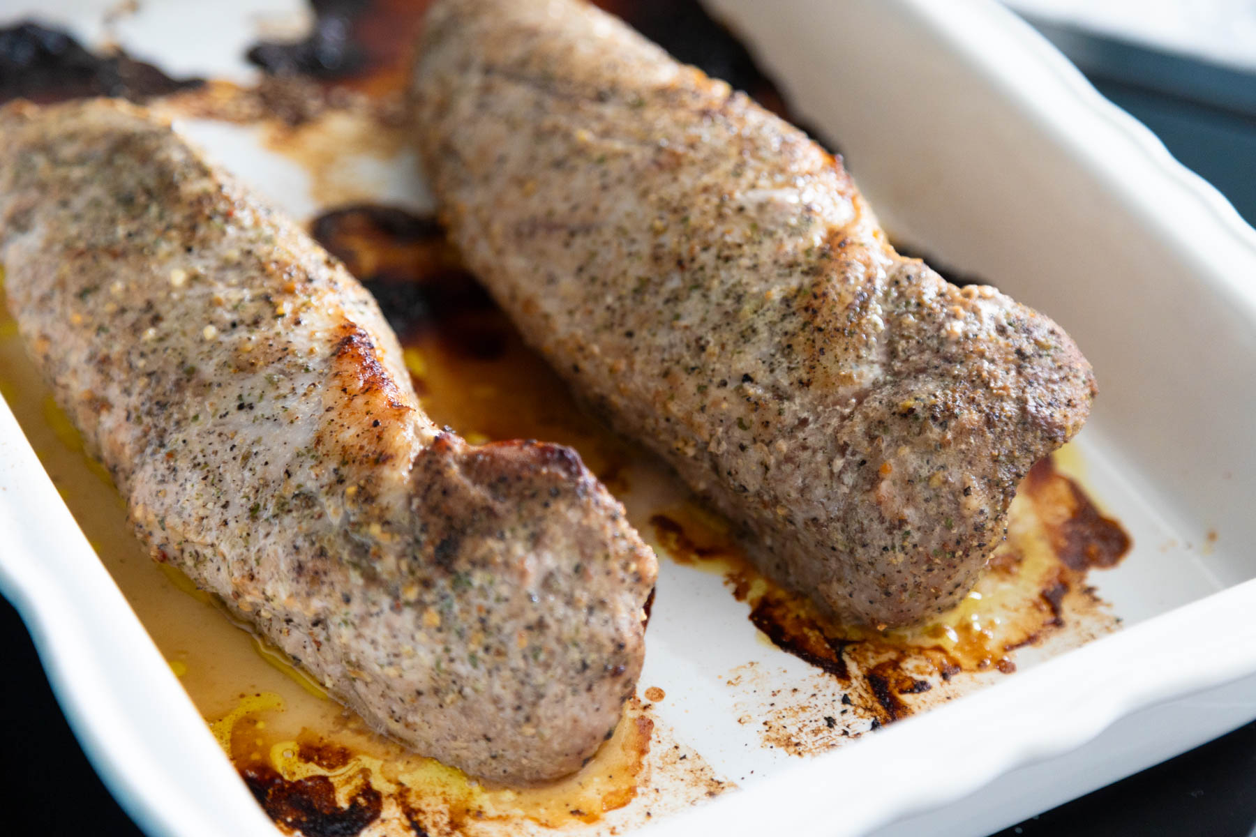 The pork tenderloins now have crispy golden edges from being roasted in the oven.