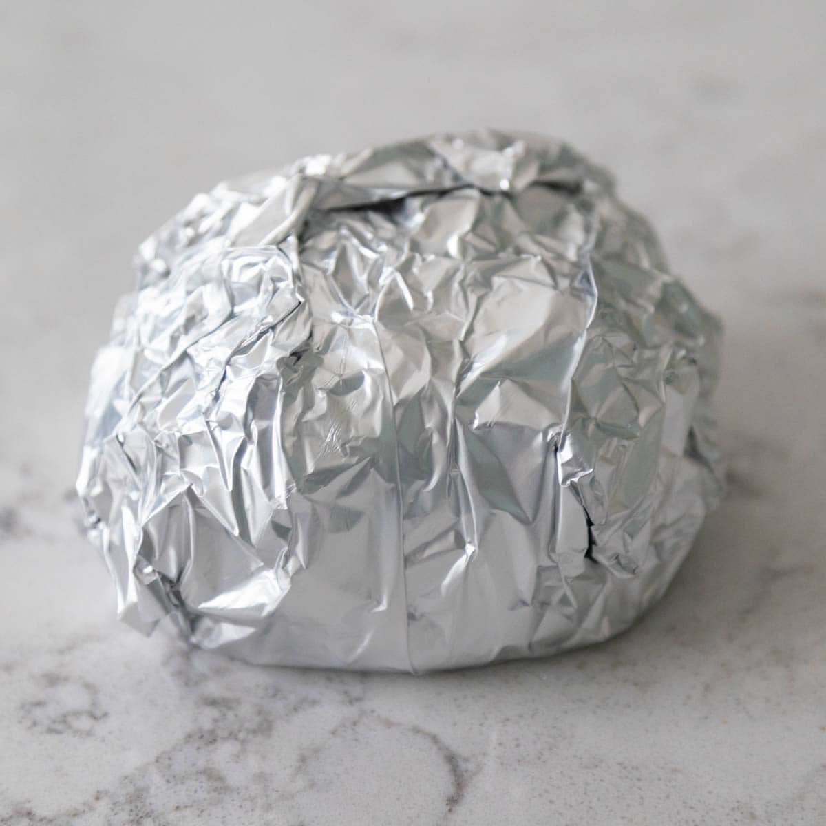 The turkey sandwich has been wrapped in foil.