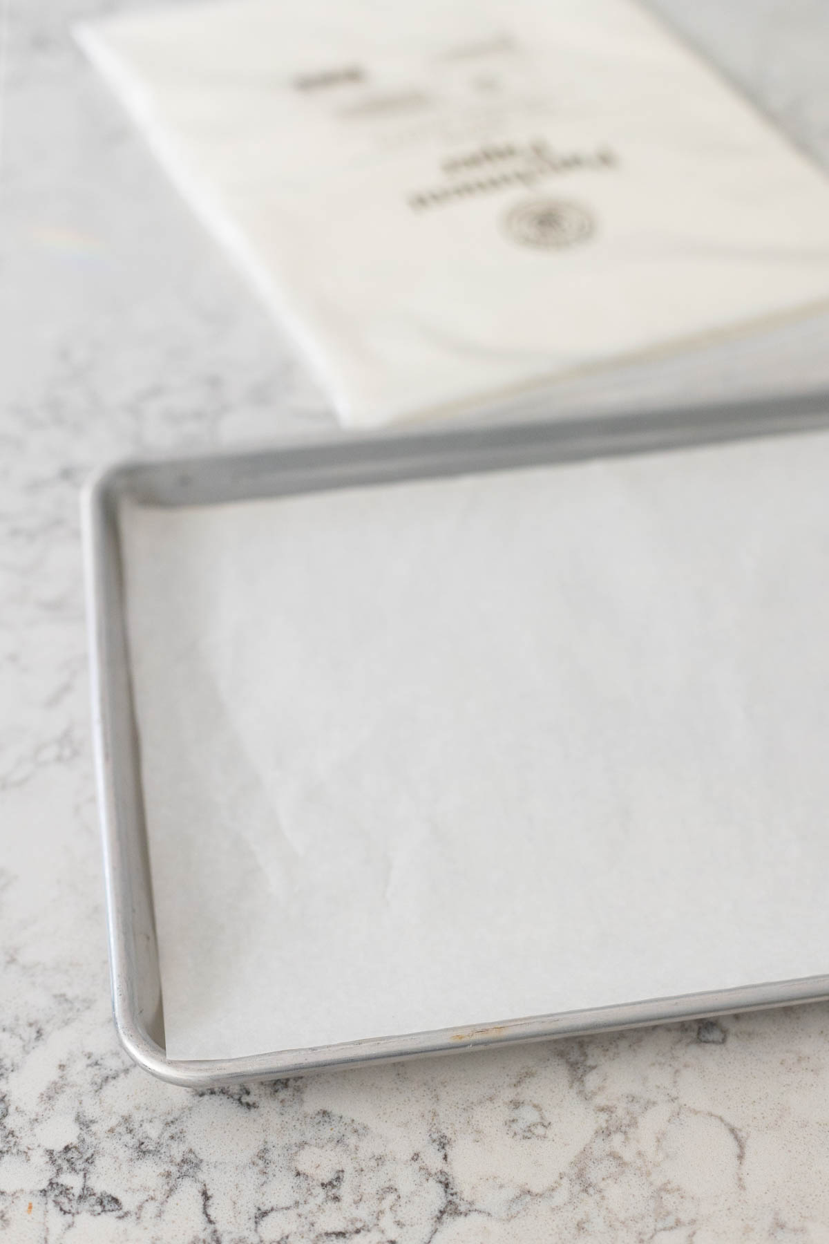Pre-cut parchment paper is placed on a metal pan.