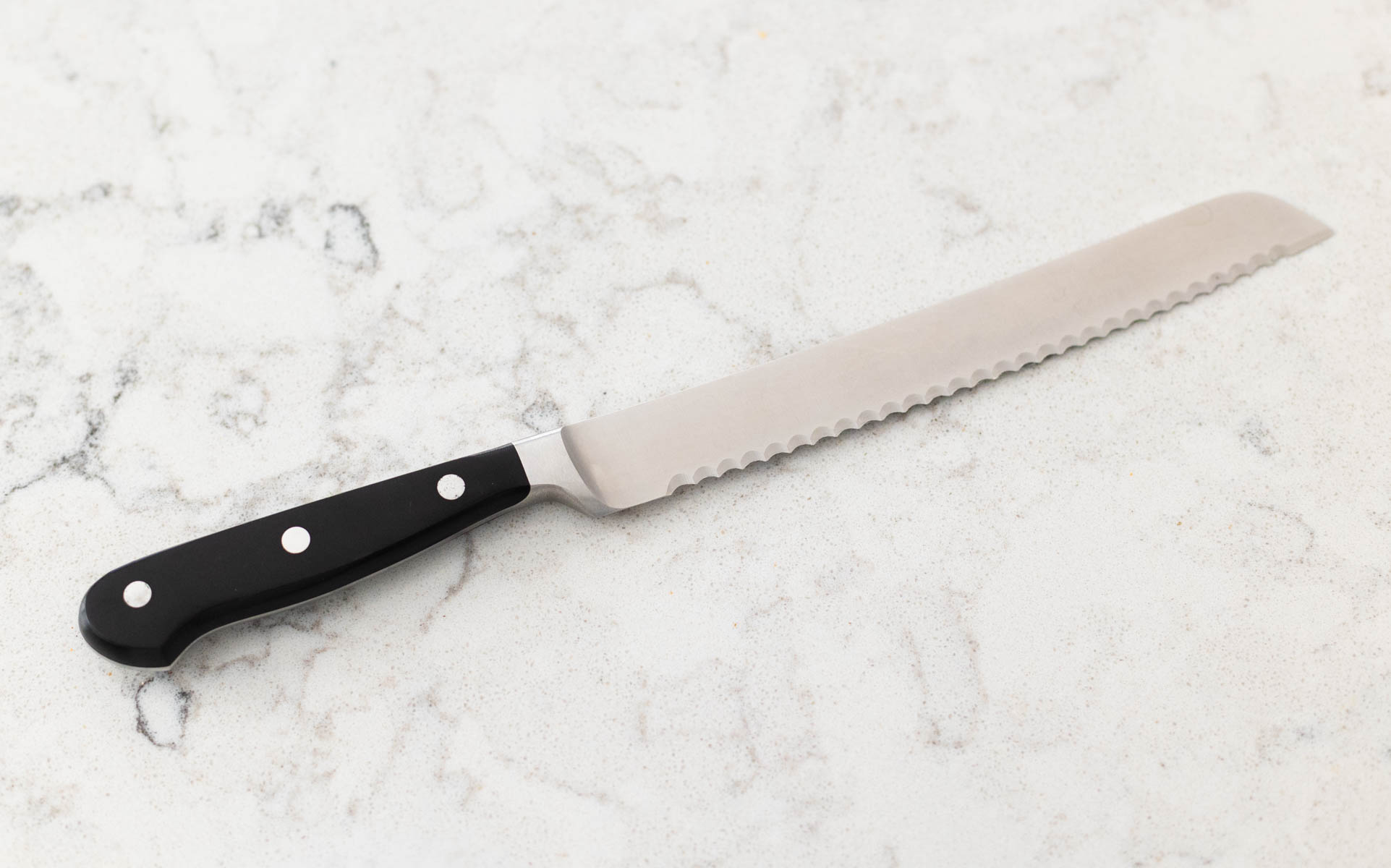A black-handled serrated bread knife is on the counter.