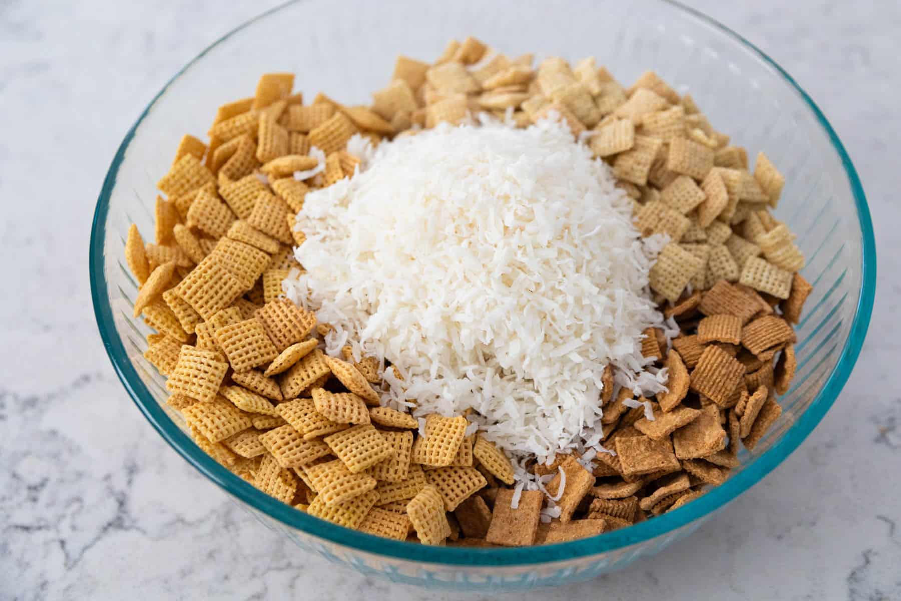 The big mixing bowl has cereal and shredded coconut about to be stirred together.