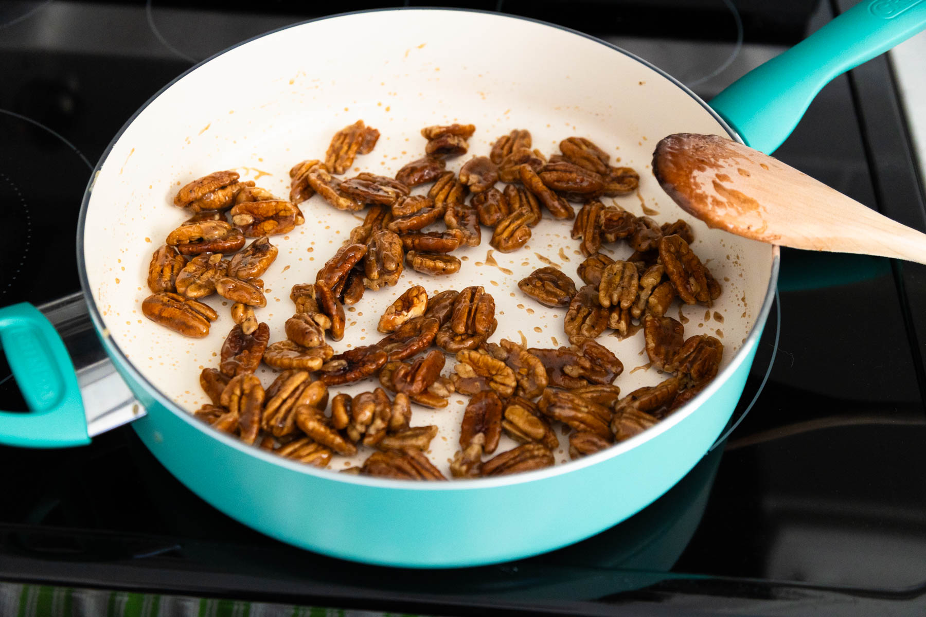 The pecans have absorbed all the glaze in the skillet.