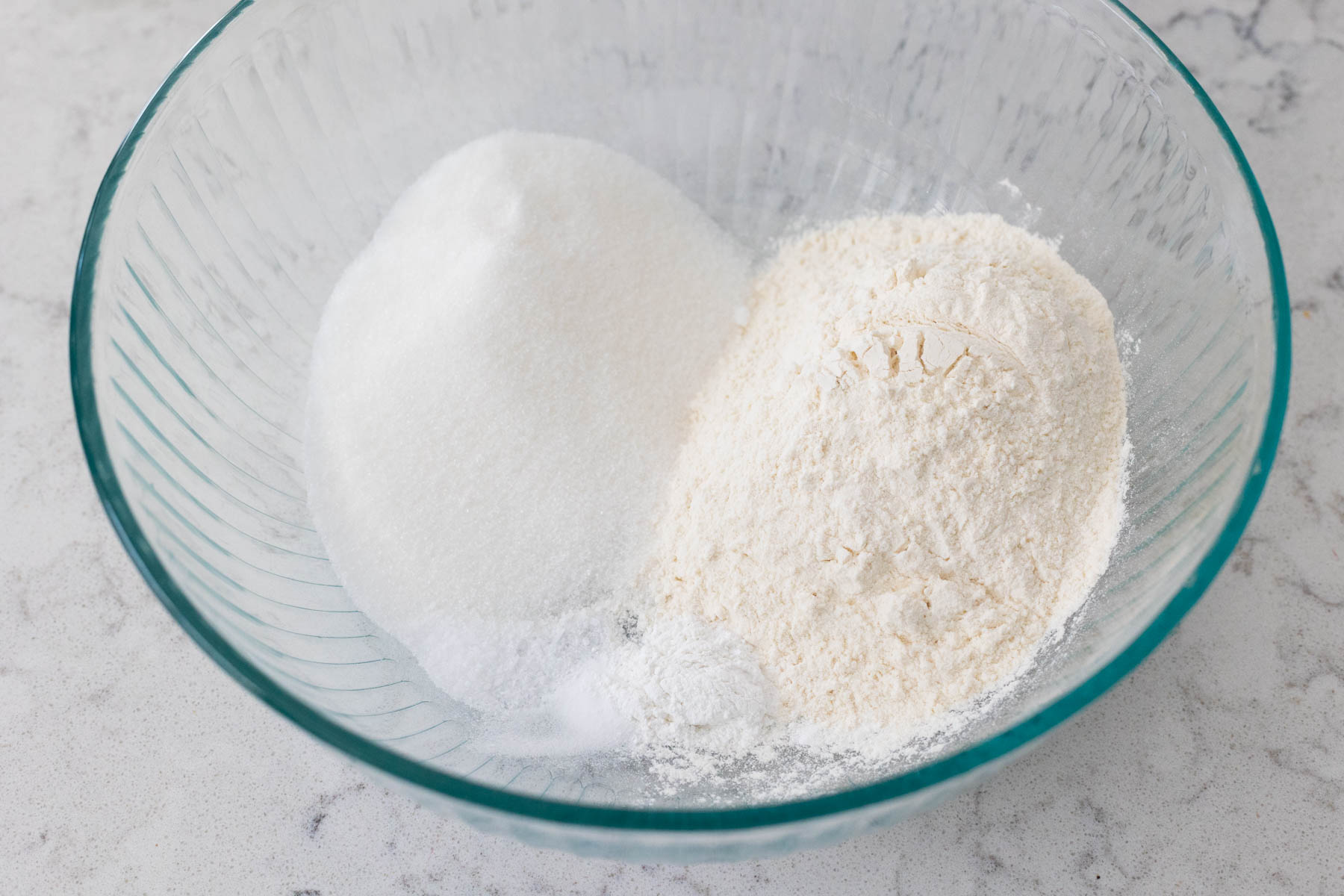 The flour, sugar, and other dry ingredients are in a large mixing bowl.