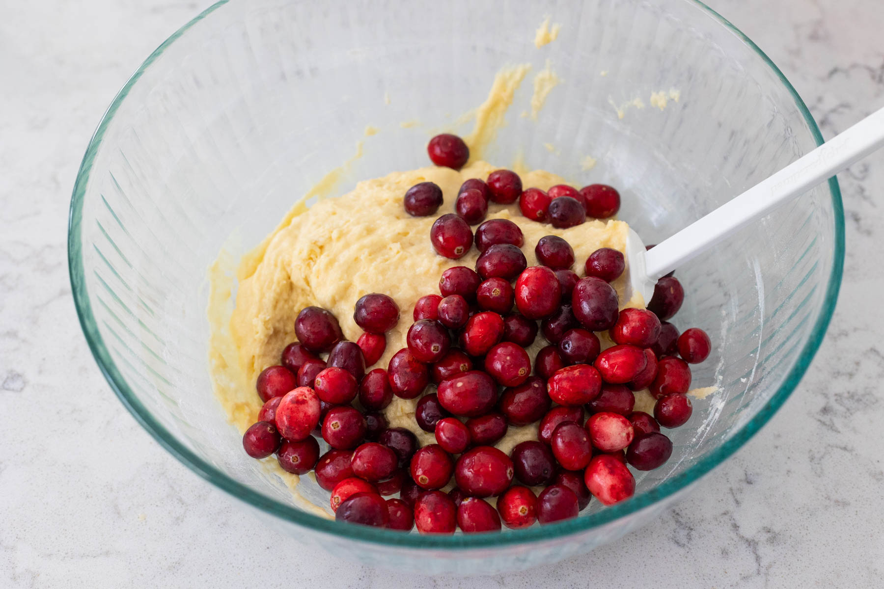 The fresh cranberries have been added to the mixing bowl.