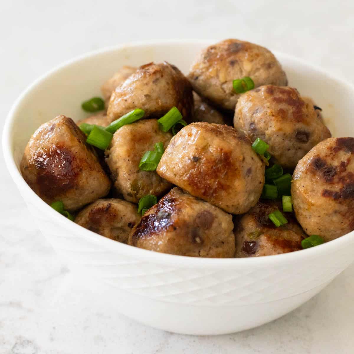 A bowl of cranberry jalapeño meatballs is ready to be added to a dinner.